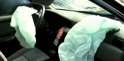 showing the front seats of a car that has been in an accident and the airbags have gone off