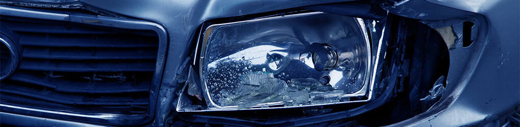 close up view of a car headlight after it's been in an accident