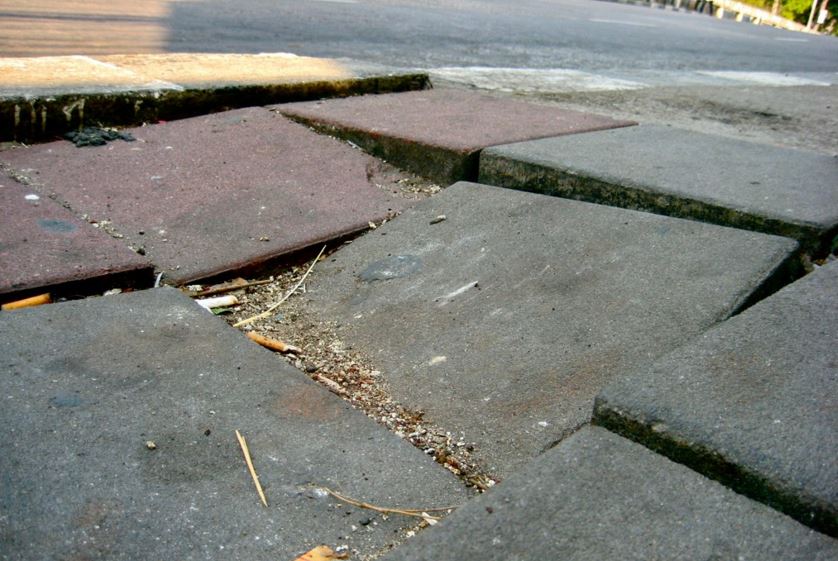 close up of a broken and uneven sidewalk
