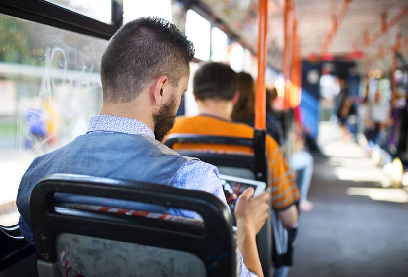 man looking at a tablet on a bus