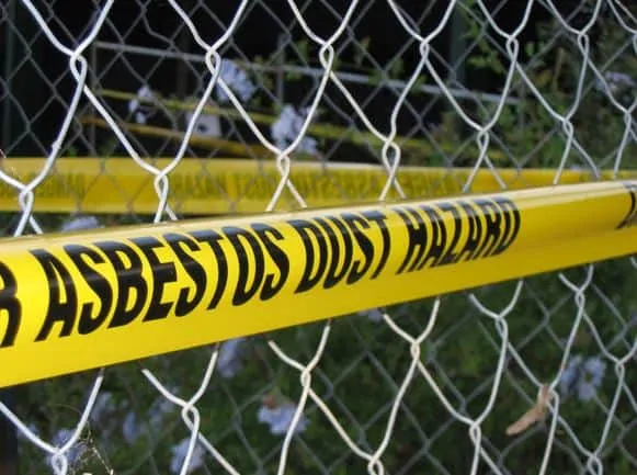 metal fence with asbestos warning tape on it