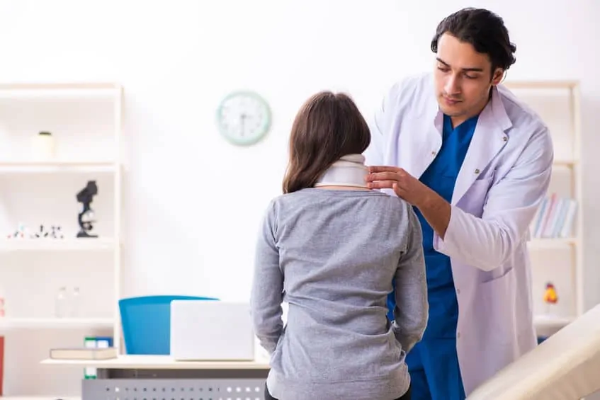 Doctor examining patient suffering from whiplash's neck and brace after a car accident