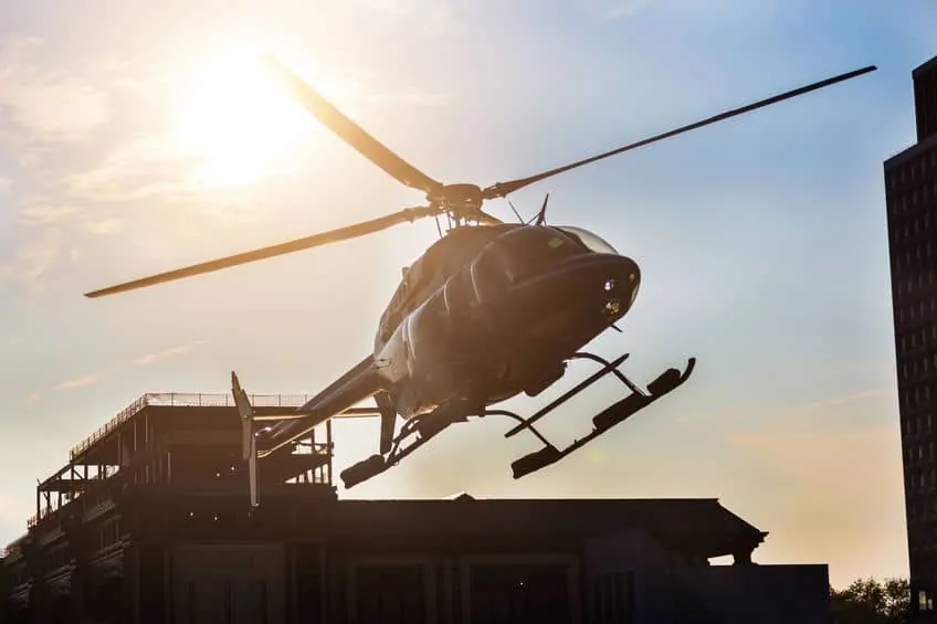 a helicopter taking off with sun in the background