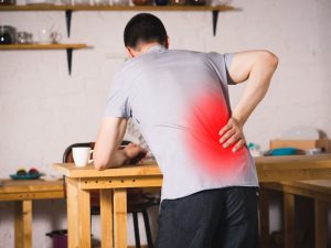 Back pain, kidney inflammation, man suffering from backache at home