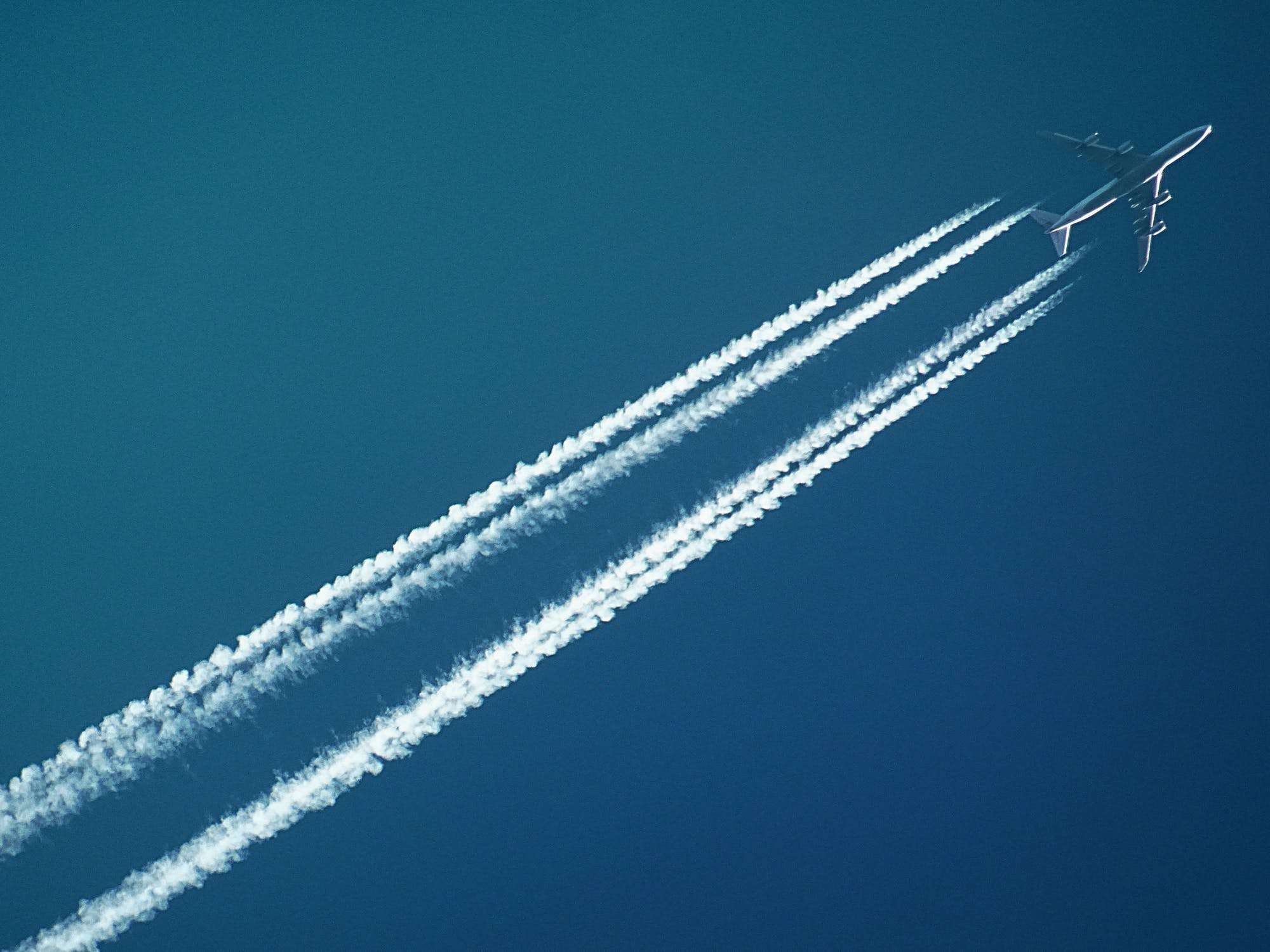 and airplane in the air with contrails
