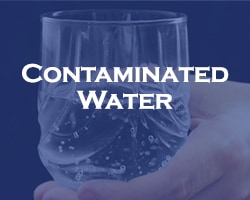 Contaminated Water - blue over a hand holding a glass with water in it