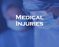 Medical Injuries - blue overlay on two doctors with scrubs and PPE on