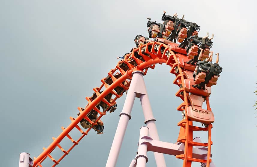 people riding an orange roller coaster